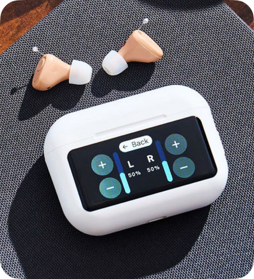 Digital hearing aid control device with earbuds on a textured surface